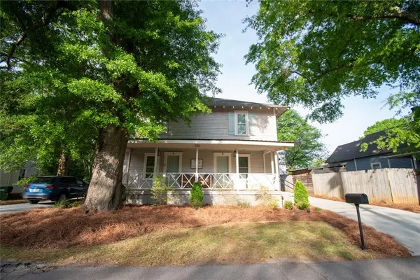 a front view of a house with a yard and potted plants