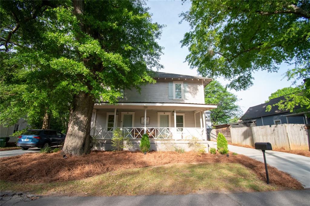 702 Radford Street Monroe, GA 30655 - Photo 1 of 49 a front view of a house with a yard and potted plants