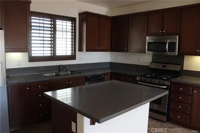 a kitchen with a sink a stove cabinets and a window