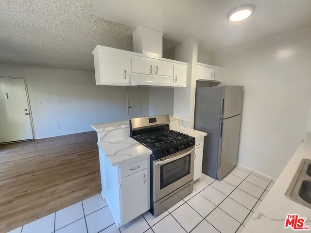 a kitchen with cabinets and steel appliances