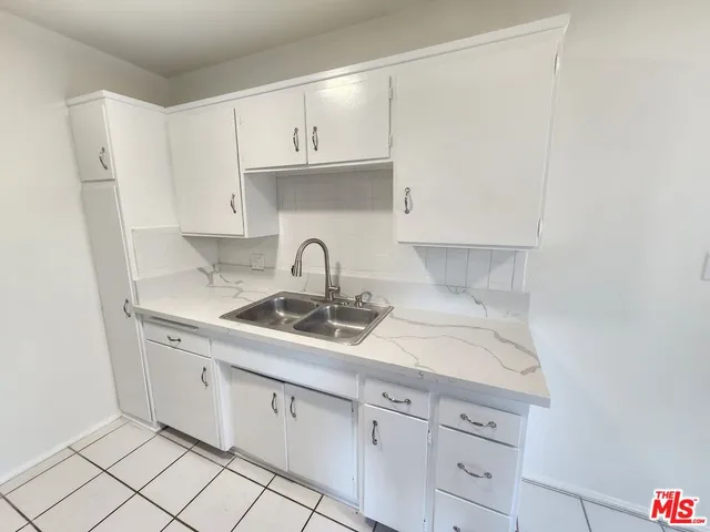 a kitchen with white cabinets and a sink