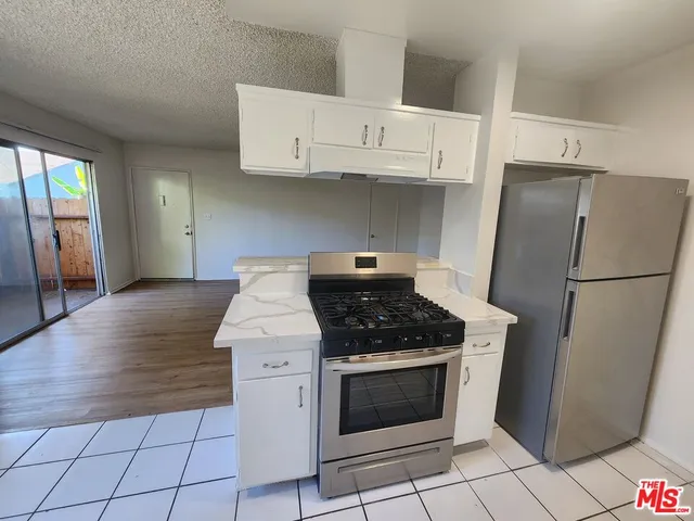 a kitchen with a stove top oven and refrigerator