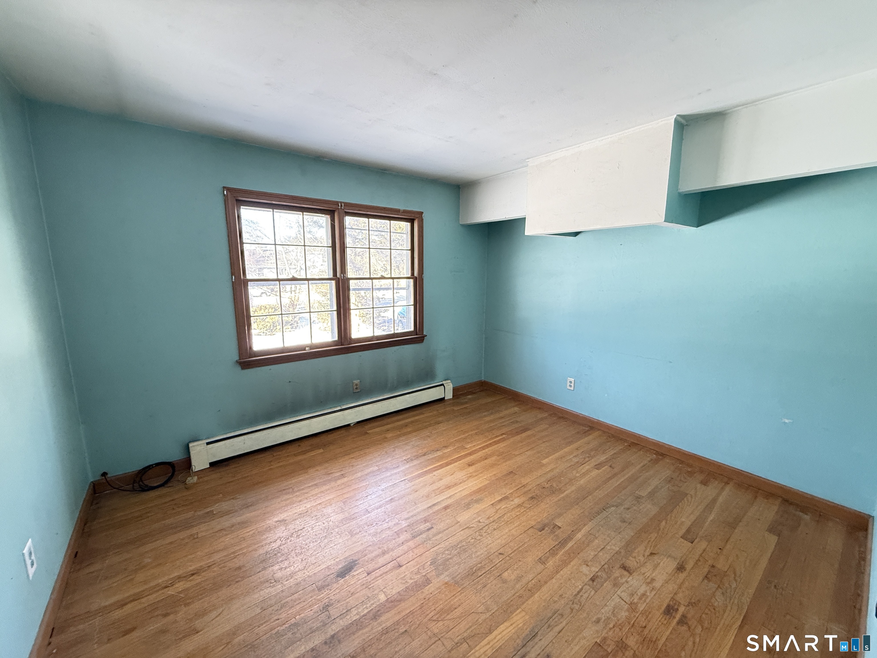 409 Boston Street Guilford, CT 06437 - Photo 18 of 28 an empty room with wooden floor and windows