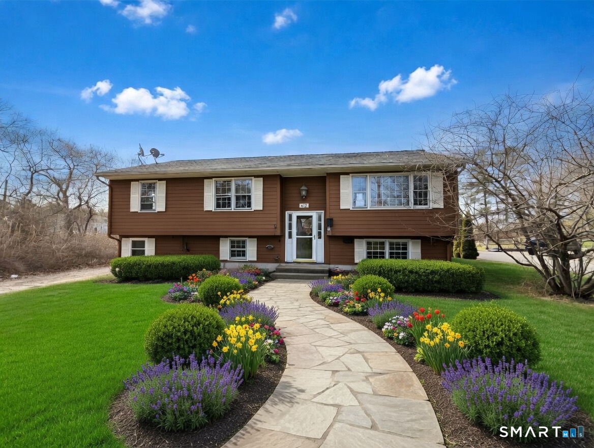 409 Boston Street Guilford, CT 06437 - Photo 2 of 28 a front view of a house with a garden and porch