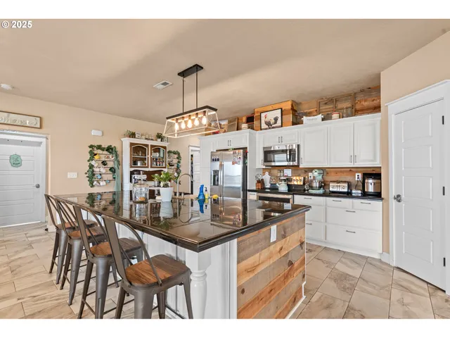 a kitchen with stainless steel appliances granite countertop a sink and a refrigerator