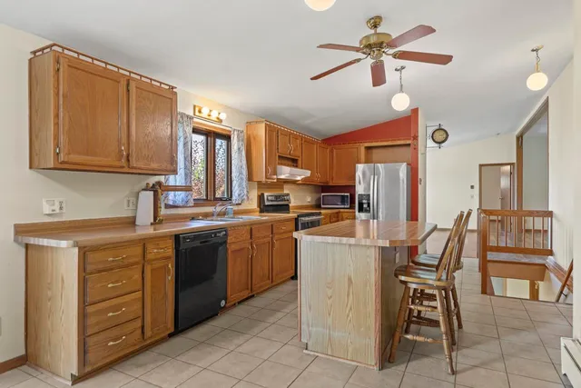 a kitchen with cabinets and chairs