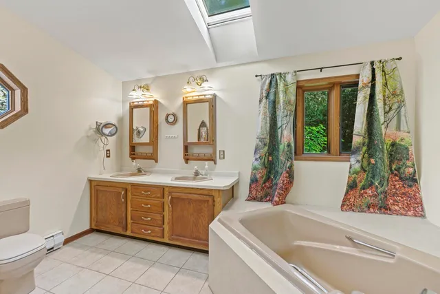 a bathroom with a tub sink and mirror