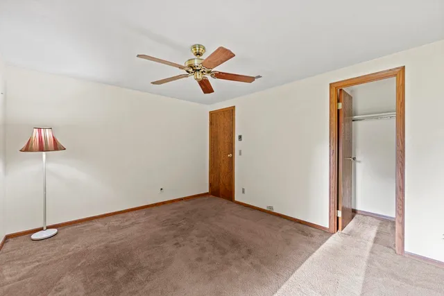 a view of a big room with wooden floor and a ceiling fan