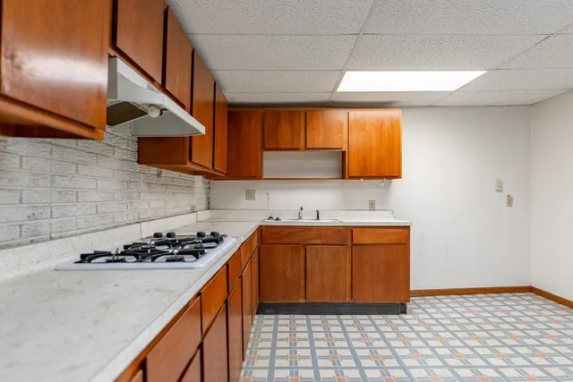 a kitchen with a sink a stove cabinets and a window