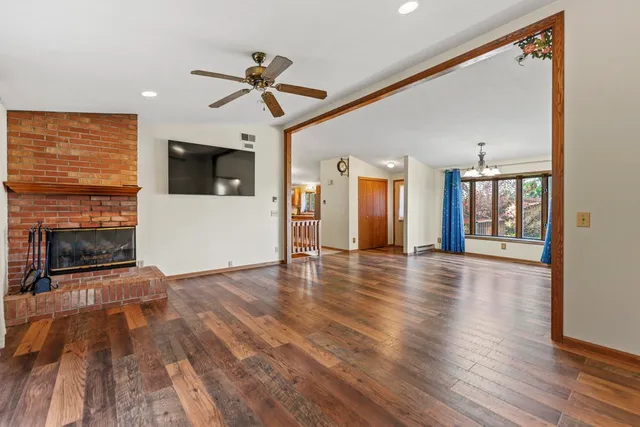a view of a livingroom with wooden floor and a ceiling fan