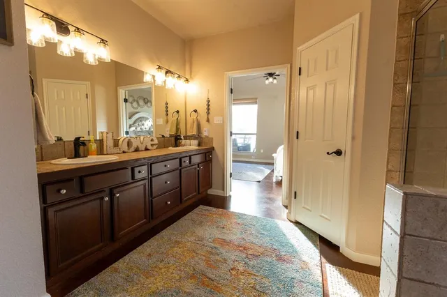 a spacious bathroom with a double vanity sink a mirror and a shower