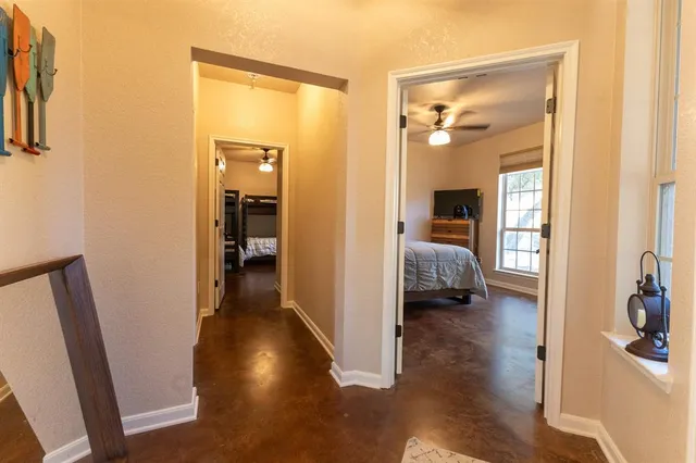 a view of a hallway with wooden floor and a bedroom