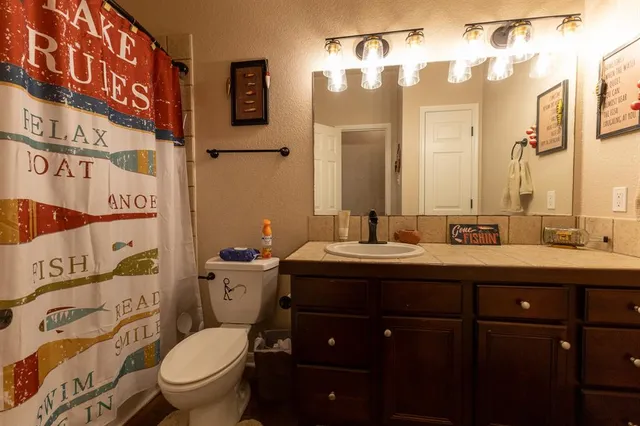 a bathroom with a toilet sink and mirror