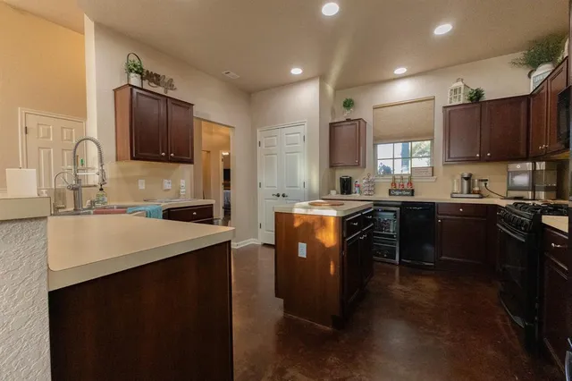 a kitchen with kitchen island granite countertop a sink stove and refrigerator