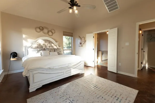 a spacious bedroom with a bed and a chandelier