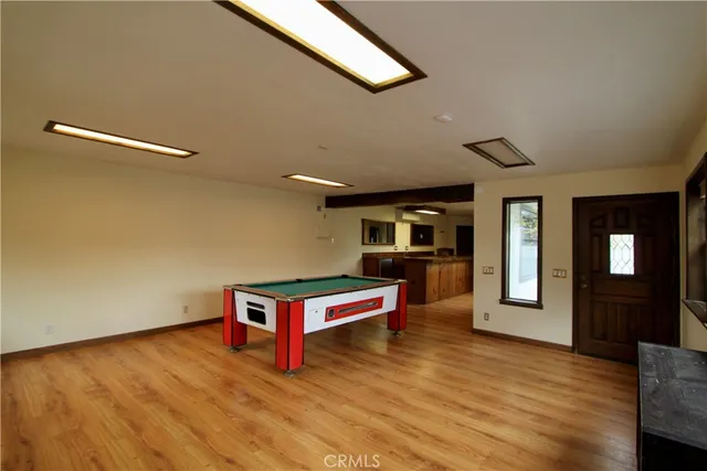 a room with pool table and large windows