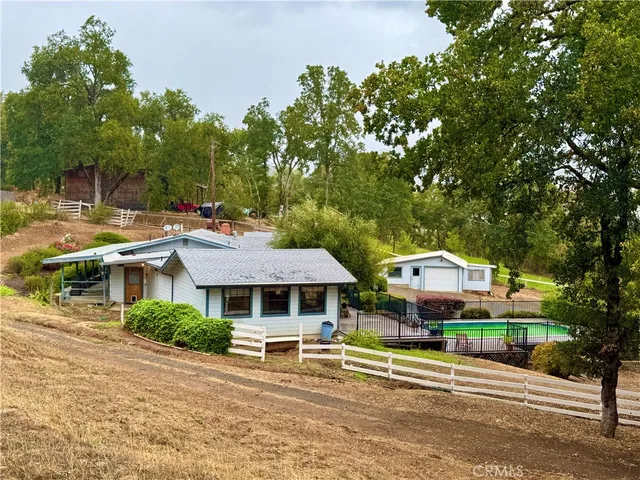a front view of a house with a garden and trees