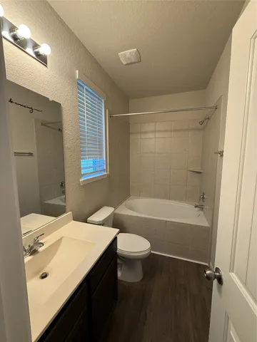 a bathroom with a sink a toilet tub and shower