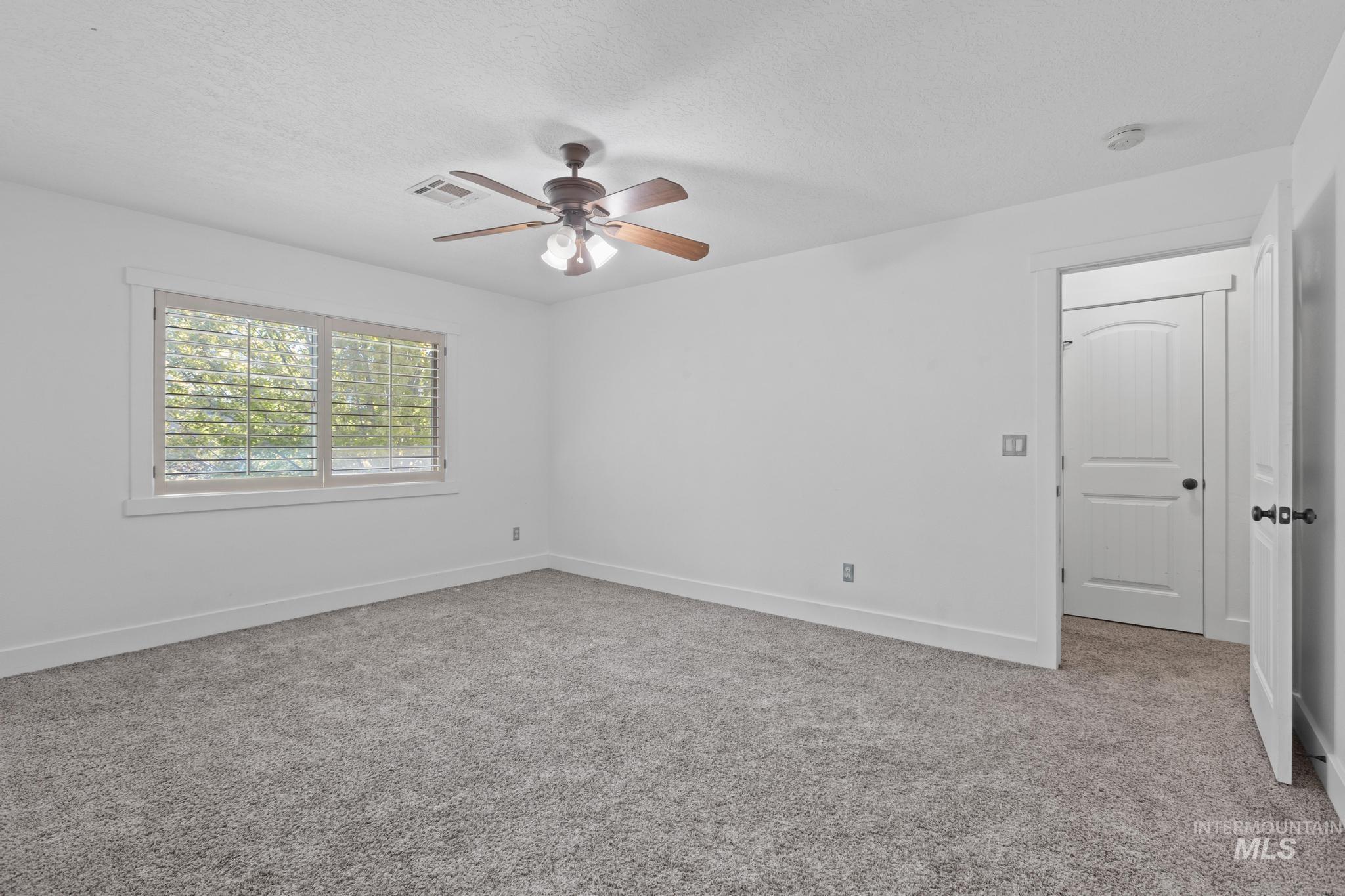 5271 West Morris Hill Road Boise, ID 83706 - Photo 20 of 31 Spare room featuring light colored carpet, a textured ceiling, and ceiling fan