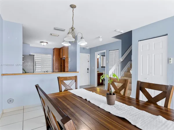 a dining room with wooden floor a chandelier a wooden table and chairs