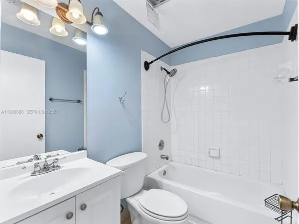 a bathroom with a sink a toilet a mirror and shower