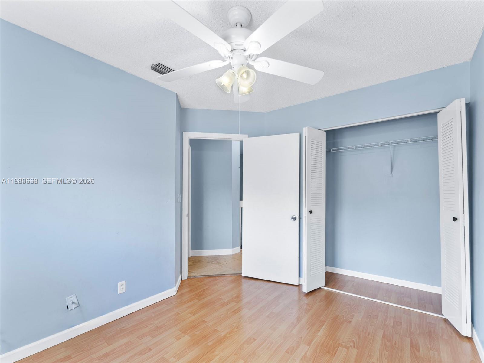 17337 Southwest 140th Court Miami, FL 33177 - Photo 29 of 41 an empty room with wooden floor and ceiling fan