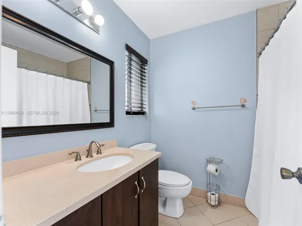 a bathroom with a sink toilet and mirror