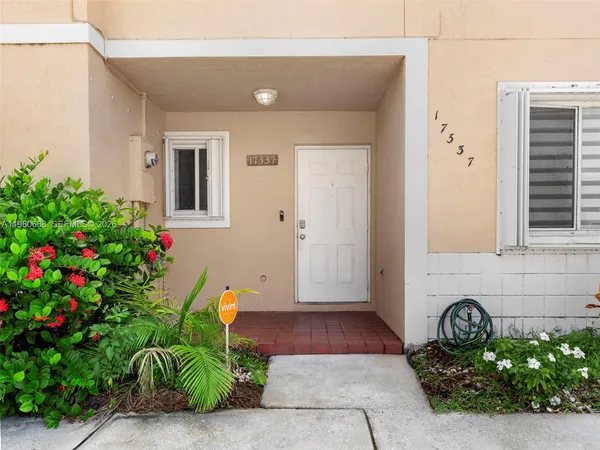 a front view of a house with plants