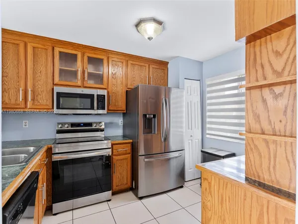 a kitchen with stainless steel appliances granite countertop a refrigerator stove and microwave