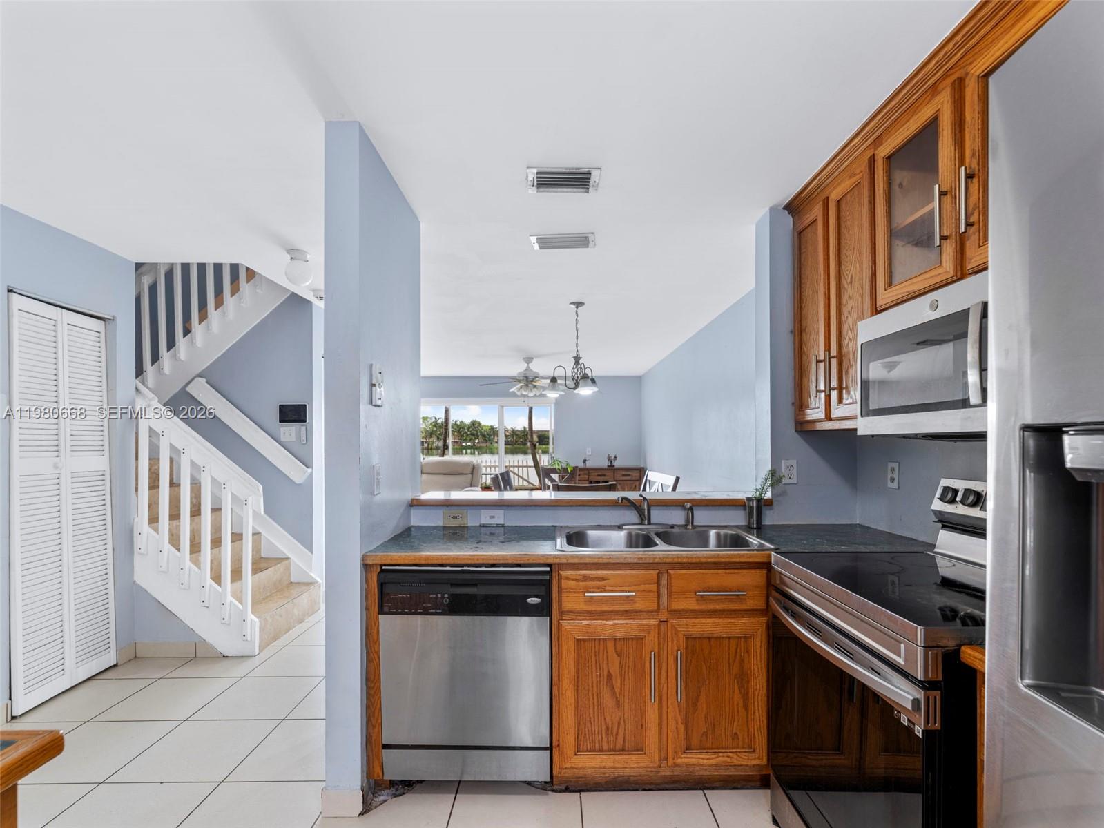 17337 Southwest 140th Court Miami, FL 33177 - Photo 10 of 41 a kitchen with granite countertop a sink stove and cabinets