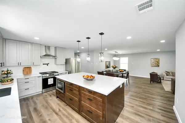 a kitchen with a stove a sink dishwasher and a refrigerator with wooden floor