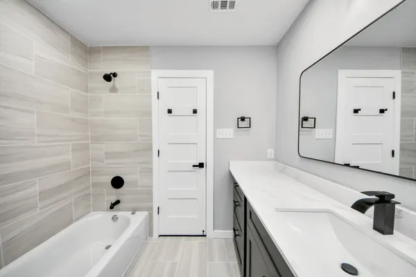 a bathroom with a bathtub a sink a vanity and a shower