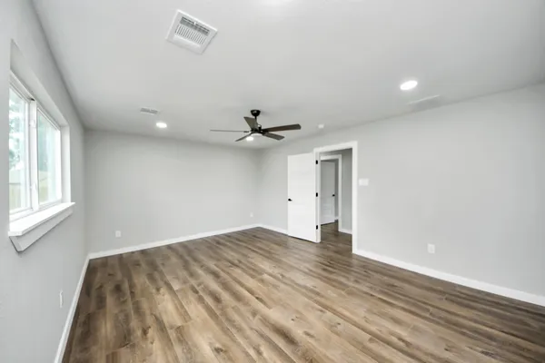 wooden floor in an empty room with a window