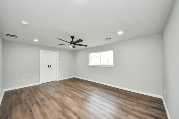an empty room with a window and a ceiling fan