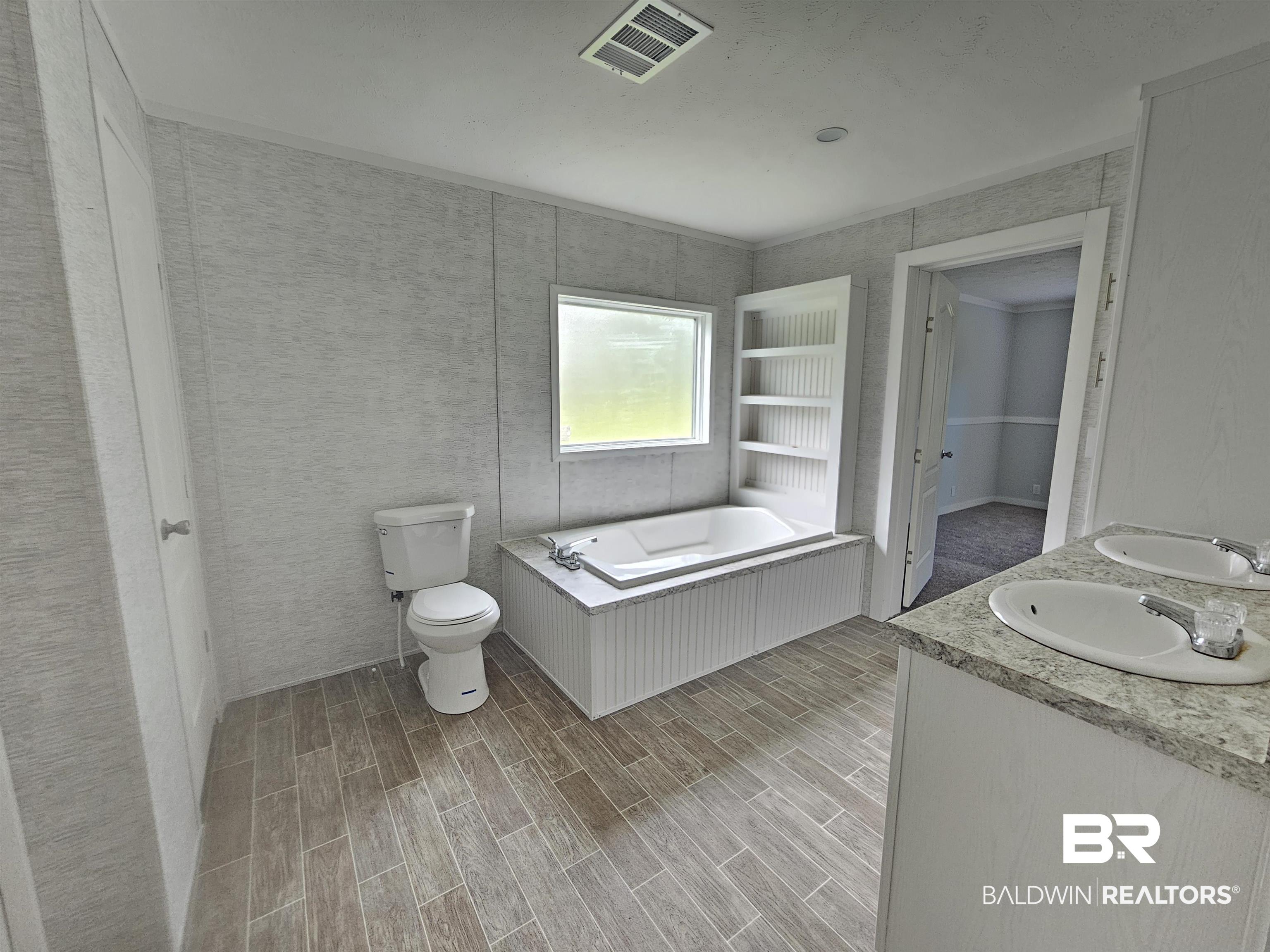 1863 Wait Road Monroeville, AL 36460 - Photo 7 of 38 Bathroom featuring double vanity, a washtub, and toilet