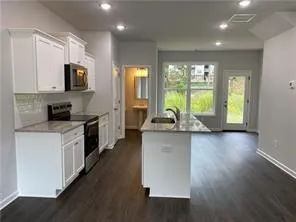 a kitchen with stainless steel appliances granite countertop a stove a sink and a microwave