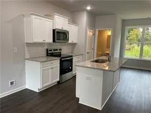 a kitchen with stainless steel appliances granite countertop a sink and a stove top oven