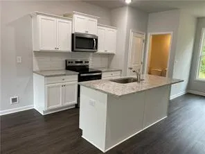 a kitchen with granite countertop a sink and a stove top oven