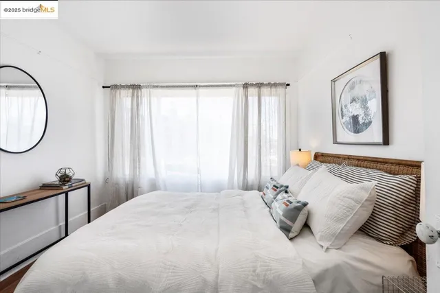 a bedroom with a bed a mirror and a window