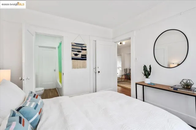 a bedroom with a bed and a dresser with mirror