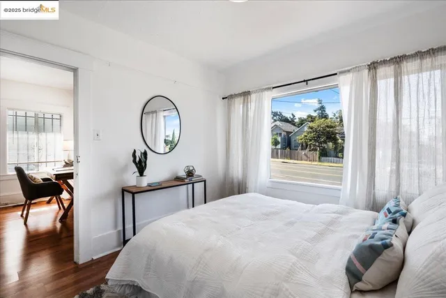 a bedroom with a bed a mirror and a large window