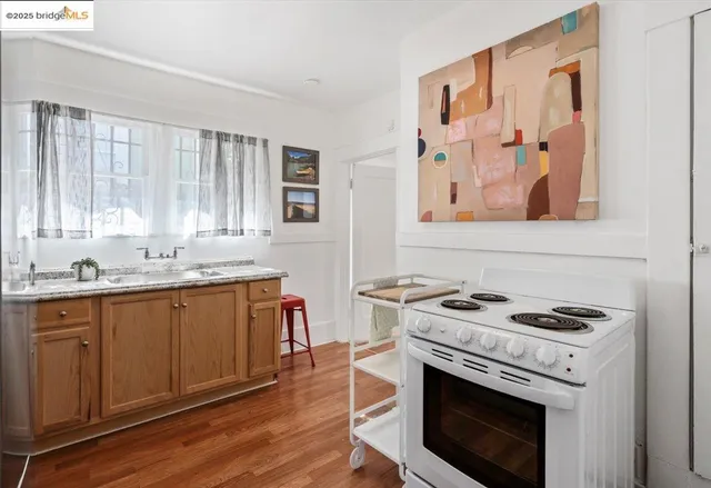 a kitchen with granite countertop a stove a sink and a microwave
