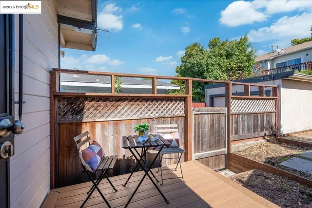 a view of a patio with table and chairs with wooden fence