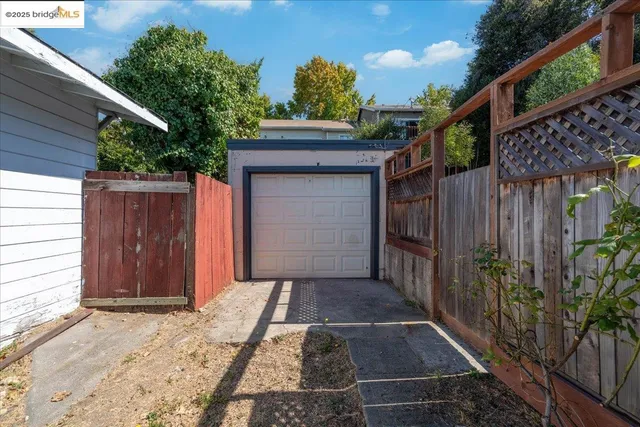 a view of backyard with small cabin and wooden fencing