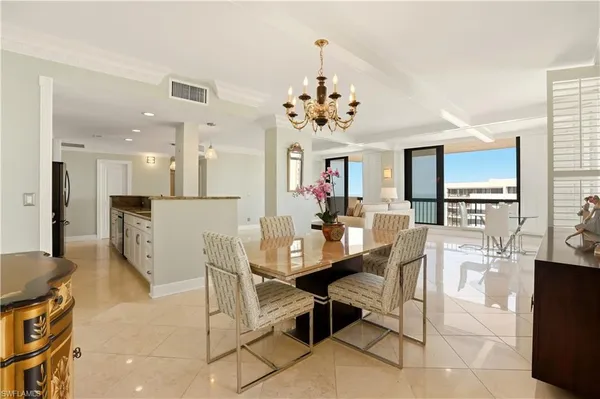a view of a dining room and livingroom with furniture wooden floor a chandelier
