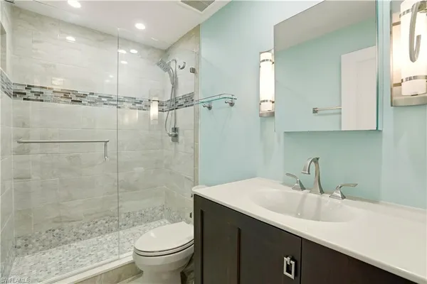 a bathroom with a sink a toilet and shower