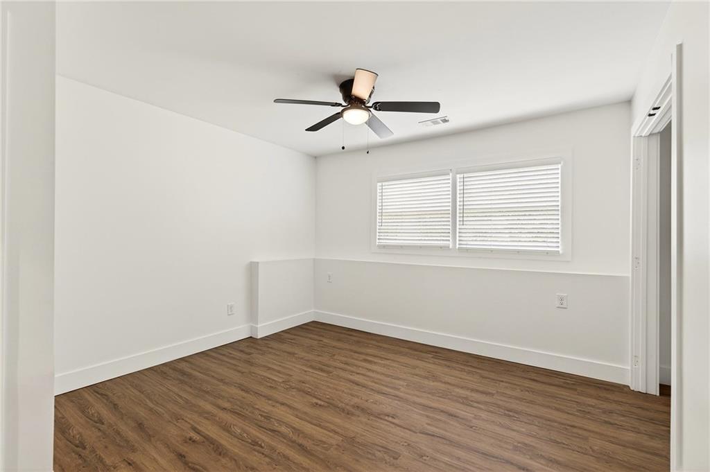 1344 Midlawn Drive Decatur, GA 30032 - Photo 60 of 87 an empty room with wooden floor ceiling fan and windows