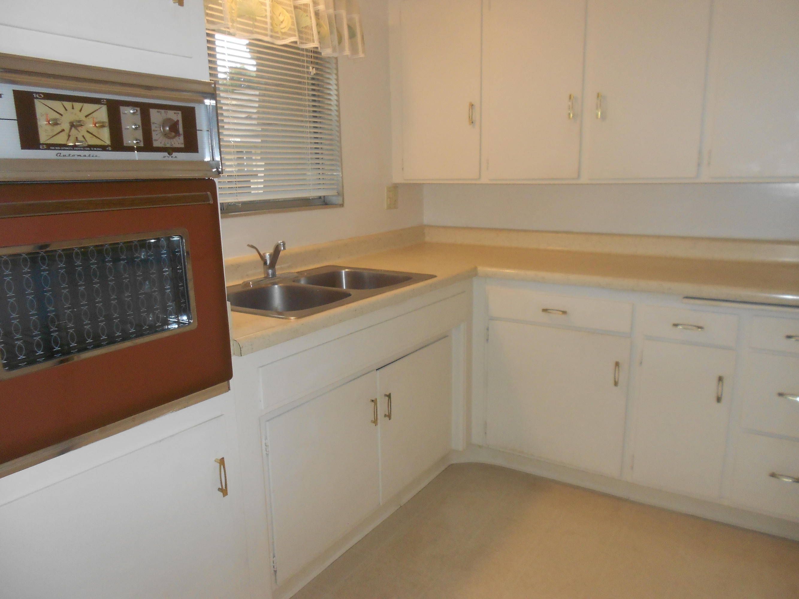 5740 Encina Road, Unit 1 Goleta, CA 93117 - Photo 7 of 9 a kitchen with granite countertop white cabinets and white appliances