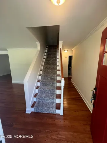 a view of entryway and hall with wooden floor