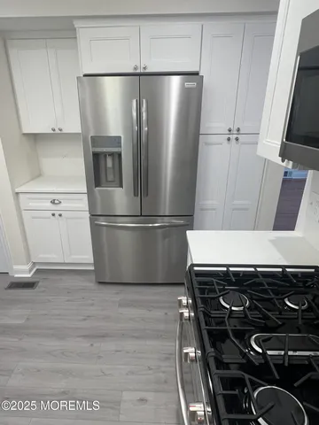 a close view of a refrigerator a stove and cabinets